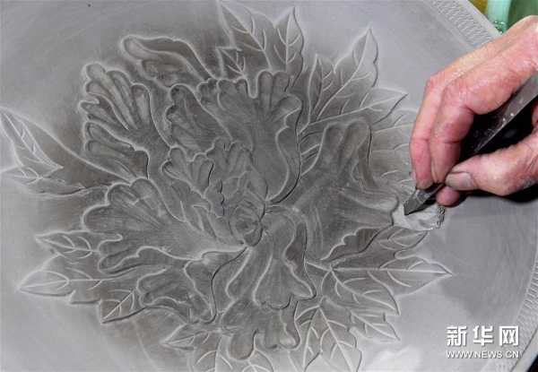 在位于河南省汝州市孟玉松的汝瓷生產(chǎn)車間內(nèi)，孟玉松對制作完成的坯體進(jìn)行雕刻（3月13日攝）。