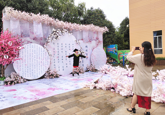 畢業(yè)生家長為孩子留影。記者 張薇 攝