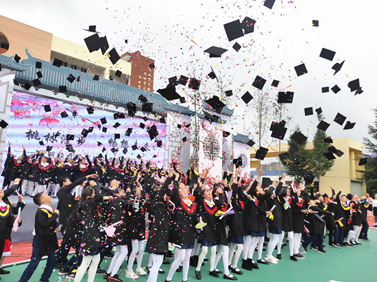 畢業(yè)生高高擲出手中的學士帽。記者 張薇 攝