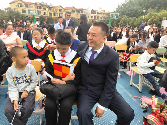 畢業(yè)生家長為孩子送上畢業(yè)賀禮。記者 張薇 攝