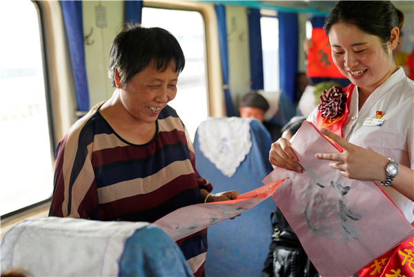 6162次慢火車乘務(wù)員為旅客送去代表祝福的“福”字，乘車大媽看著“?！弊致冻鲂腋５男θ?。