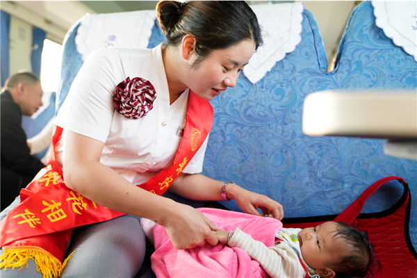 慢火車乘務(wù)員幫助家長(zhǎng)照看小朋友，扮演起臨時(shí)媽媽的角色。