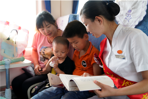 慢火車志愿者在列車“讀書角”，與乘車的小學(xué)生一起朗讀文章，相互交流、探討文章中的故事情節(jié)。