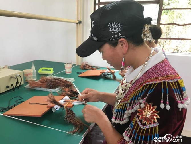 在每個黃豆大小的設(shè)備上穿10圈銅絲是40歲的侯景每天的工作。（記者 何川 攝）