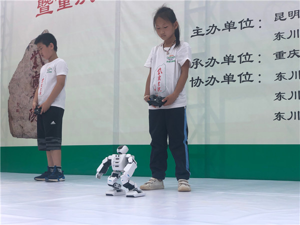 比賽中，同學(xué)們控制機器人做出太極動作。