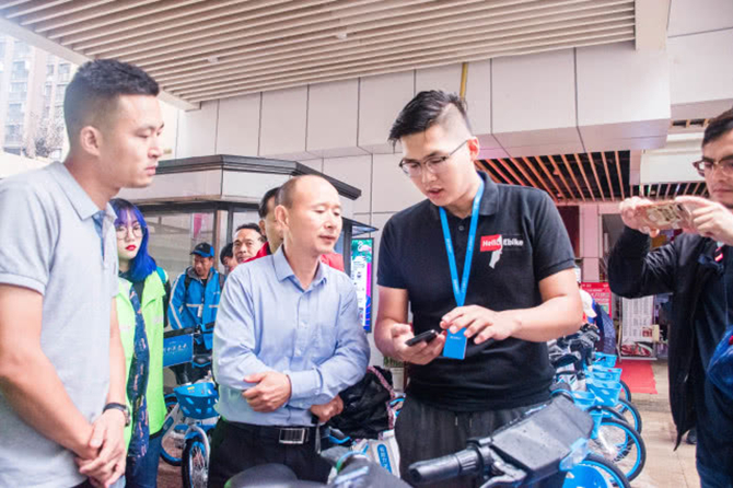哈啰出行工作人員向市文明辦、市城市管理局現(xiàn)場演示助力車使用方法