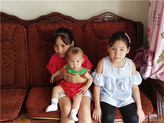 傈僳族三姐妹坐在新家里。記者刁鳳云攝