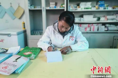 圖為嘎宗卓瑪正在醫(yī)務(wù)室填就診單。 謝藝觀 攝