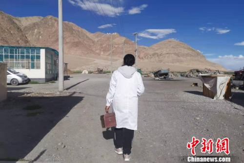 圖為嘎宗卓瑪從病人家里出來(lái)，正往村醫(yī)務(wù)室走去。 謝藝觀 攝