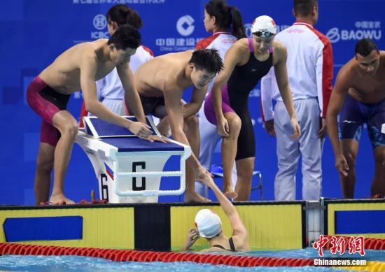 10月21日晚間，第七屆世界軍人運動會9項游泳決賽在湖北省武漢市舉行，中國隊獲得7個項目冠軍，其中打破了女子100米自由泳、男子200米自由泳、女子100米仰泳、男子400米混合泳和男女4x100米自由泳接力5個項目的國際軍事體育理事會紀錄，創(chuàng)造了女子1500米自由泳的國際軍事體育理事會紀錄。圖為中國隊奪冠后，隊友們與第四棒選手朱夢惠握手慶祝。<a target='_blank' href='http://www.chinanews.com/'>中新社</a>記者 侯宇 攝