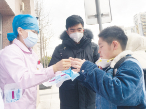 醫(yī)護(hù)人員發(fā)放口罩并教授正確佩戴方法。