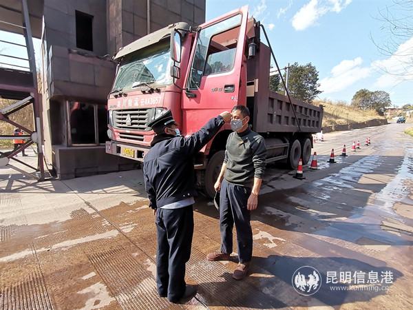 16.安寧市金方街道設在昆鋼北大門的疫情防控檢查點上，昆鋼后勤保障部楊永前細致檢查過往車輛，為每一位途經的人員測量體溫。劉家榮 攝