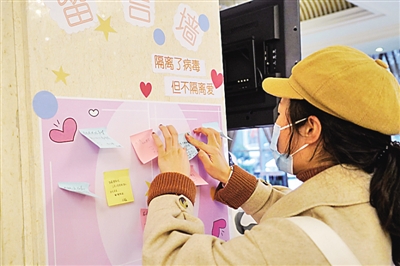 春節(jié)期間，一名結(jié)束醫(yī)學(xué)觀察的武漢滯留旅客在留言墻上寫(xiě)下感謝和祝福的話，傳遞信心力量。新華社發(fā)