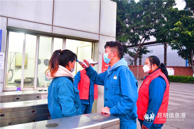 工作人員對(duì)堅(jiān)守崗位的進(jìn)出職工測(cè)量體溫。