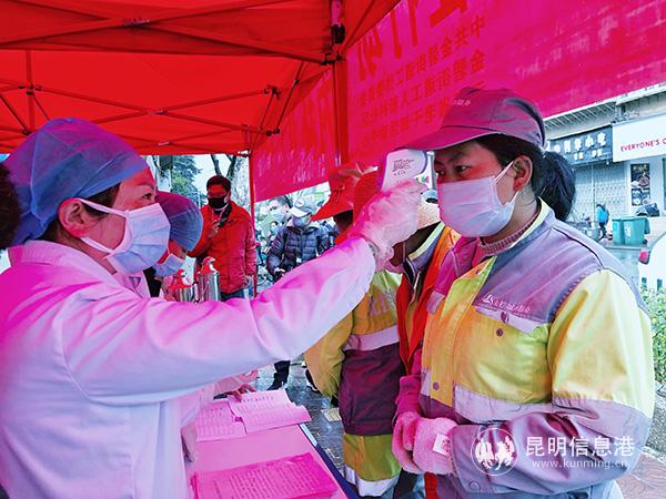 醫(yī)生為環(huán)衛(wèi)工人測(cè)體溫。