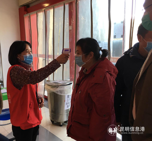 工作人員為進(jìn)入超市的顧客測(cè)量體溫