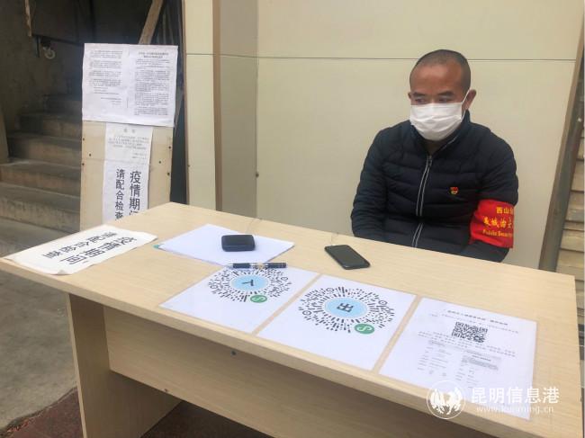 社區(qū)黨員志愿者晉建忠在樓棟前值守。