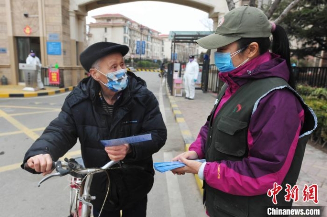 志愿者向社區(qū)居民發(fā)送“禁食野味”宣傳單?！⊥鹾I 攝