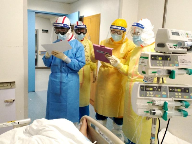 2月11日，在武漢同濟醫(yī)院中法新城院區(qū)ICU病房內，來自北京協(xié)和醫(yī)院的醫(yī)護人員在病床旁查房交班。