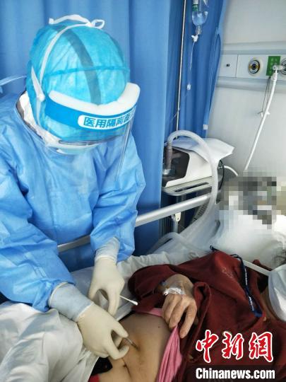 圖為福建省第十一批支援湖北醫(yī)療隊隊員黃華清在武漢金銀潭醫(yī)院為病人做治療?！∈茉L者供圖 攝