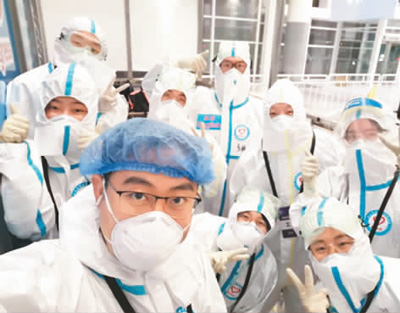 　3月21日夜班結(jié)束前，在崗學(xué)生志愿者與帶隊(duì)老師合影。資料圖片