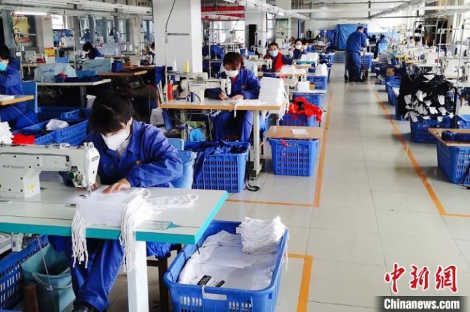 資料圖：甘肅嘉峪關(guān)企業(yè)加班加點(diǎn)趕制紗布口罩和防護(hù)服。