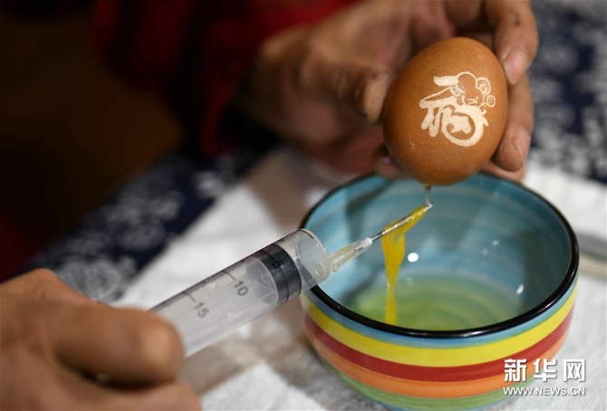 4月17日，在石家莊市橋西區(qū)非遺傳承基地，民間藝人張曉賀用針管將蛋液取出。新華社發(fā)（陳其保 攝）