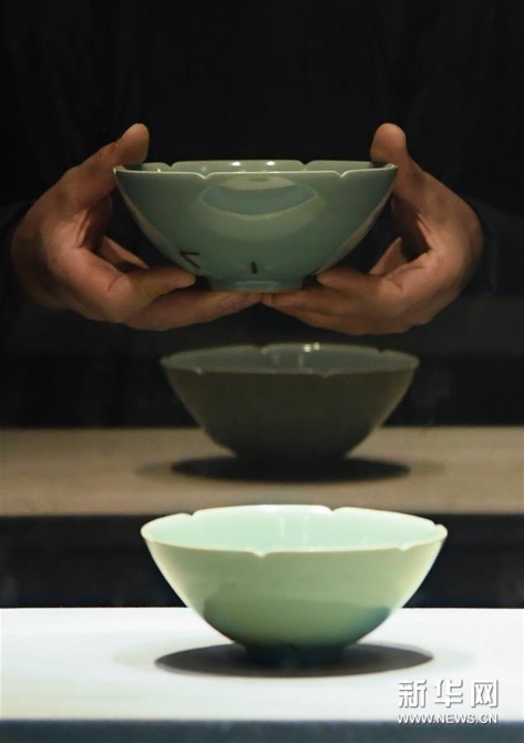 5劉杰在浙江博物館將自己做的碗（上）和展出的南宋青瓷“馬蝗絆”比較，以進行改進（2019年12月7日攝）。 新華社記者 翁忻旸 攝