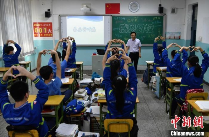 高考前的“最后一課”同學(xué)們向班主任做比心手勢(shì)