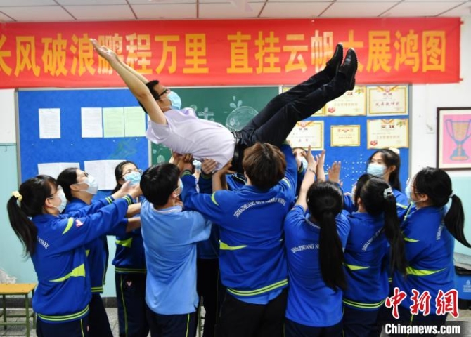圖為同學(xué)們將老師舉高拋起，表達(dá)著自己對(duì)老師的感謝之情。　翟羽佳 攝