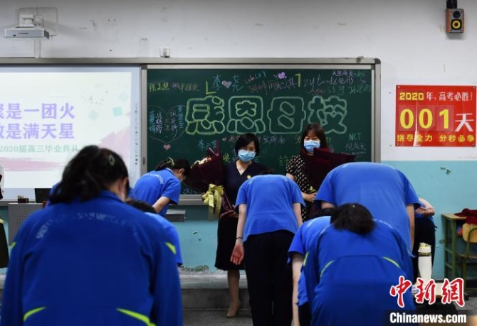 圖為同學(xué)們向教授他們知識(shí)的老師鮮花，并深深的鞠躬?！〉杂鸺?攝