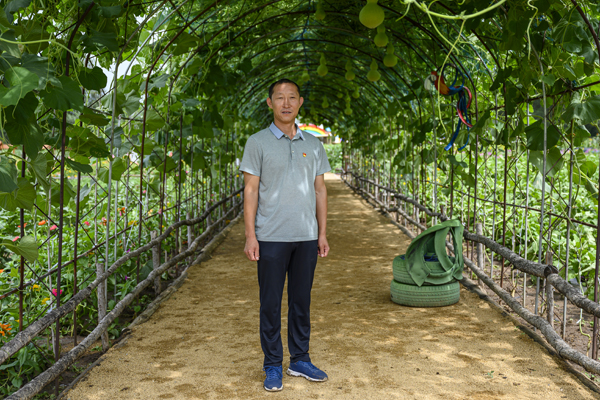 2020年8月，內(nèi)蒙古興安盟義勒力特嘎查，義勒力特嘎查黨支部書記白雙龍站在“開心果園”的葫蘆藤下。