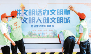 6青年志愿者清潔公交站臺文明宣傳欄。昆明公交集團(tuán)供圖