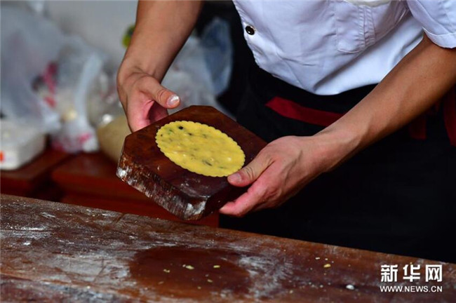 5 9月13日，在河南省商丘市夏邑縣太平鎮(zhèn)聶陳樓村，張旭在拌月餅餡。新華社記者 馮大鵬 攝