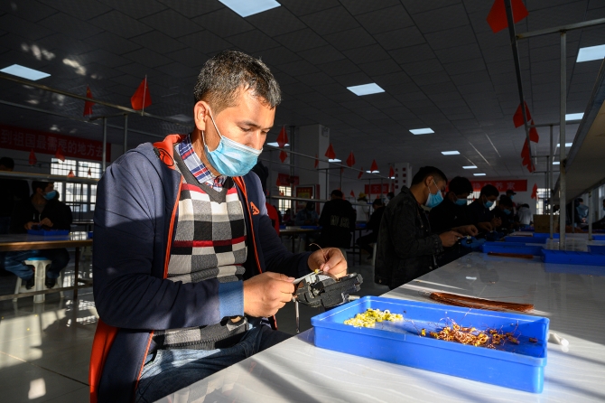 2020年10月20日，新疆克州阿克陶縣巴仁鄉(xiāng)，一位工作人員在車間里制作線圈。