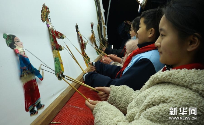 12月15日，在位于河南省許昌市建安區(qū)蘇橋鎮(zhèn)的河南省潤(rùn)知非物質(zhì)文化遺產(chǎn)研學(xué)旅行基地，小學(xué)生在體驗(yàn)操作皮影。