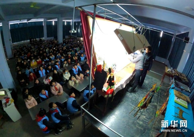 12月15日，在位于河南省許昌市建安區(qū)蘇橋鎮(zhèn)的河南省潤(rùn)知非物質(zhì)文化遺產(chǎn)研學(xué)旅行基地，許昌陳氏皮影第四代傳人陳志國(guó)和徒弟一起為學(xué)生演出皮影戲《武松打虎》。新華社發(fā)（牛書(shū)培 攝）