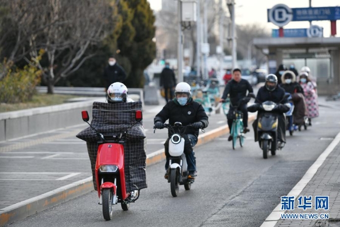 12月29日，行人騎車經(jīng)過北京宣武門路口。當(dāng)日，入冬最強(qiáng)寒潮來襲，多地迎來今冬最寒冷天氣。新華社記者 李鑫 攝