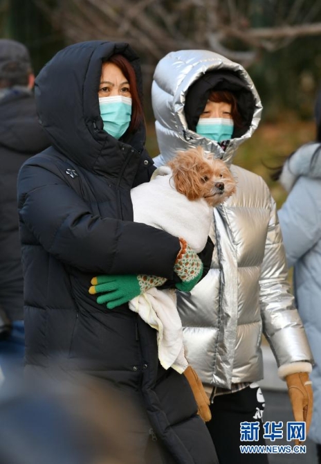 　12月29日，行人抱著寵物從北京宣武門路口走過。當(dāng)日，入冬最強(qiáng)寒潮來襲，多地迎來今冬最寒冷天氣。新華社記者 李鑫 攝