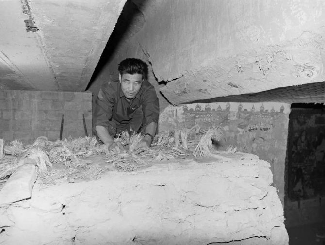 △1975年，莫高窟220窟甬道修復(fù)。（敦煌研究院提供）64年來(lái)，李云鶴共修復(fù)了4000平方米壁畫(huà)、500多身塑像，而且做到零失誤。在他手上，莫高窟里被“病害纏身”的壁畫(huà)和塑像“重獲新生”。