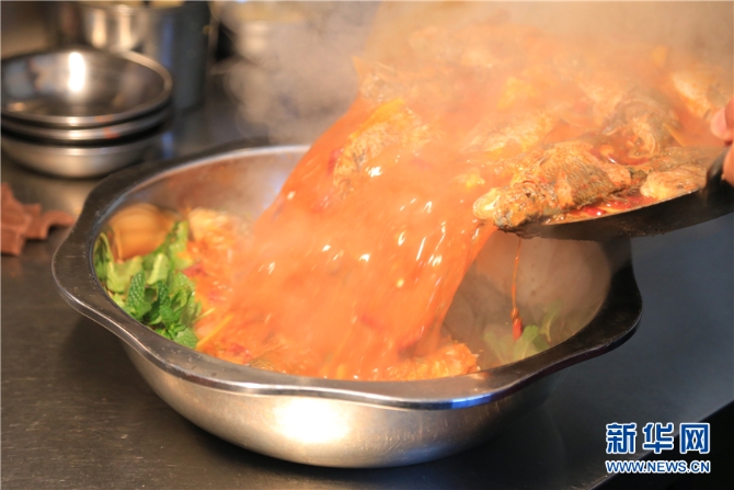 薄荷打底后，倒入糊辣魚（1月6日攝）。新華網(wǎng)發(fā)（李娜 攝）