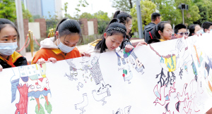 同學(xué)用畫(huà)筆描繪世界水日主題百米長(zhǎng)卷，并紛紛寫(xiě)下寄語(yǔ)。記者趙偉攝