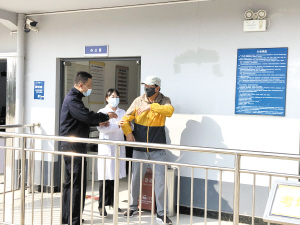 唐先生（右）在工作人員陪同下進(jìn)入候考室。