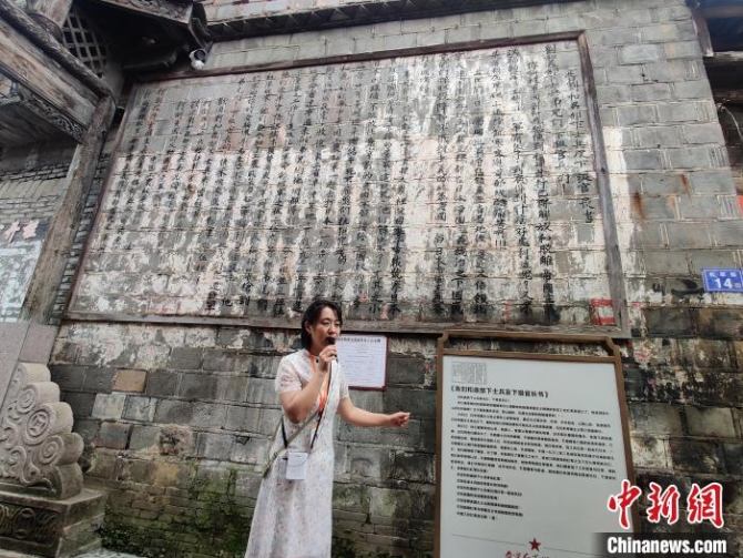 緩步前行，只見“紅軍街”牌坊下，滿滿一墻的文告映入眼簾。　葉秋云 攝