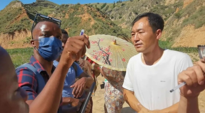  7月14日，山西省呂梁市興縣蔡家崖鄉(xiāng)沙壕村，喀麥隆留學(xué)生門杜向村民請(qǐng)教脫貧經(jīng)驗(yàn)。