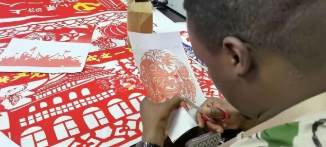 7月14日，山西省呂梁市興縣蔡家崖鄉(xiāng)沙壕村，非洲青年在興縣體驗(yàn)非遺剪紙藝術(shù)。