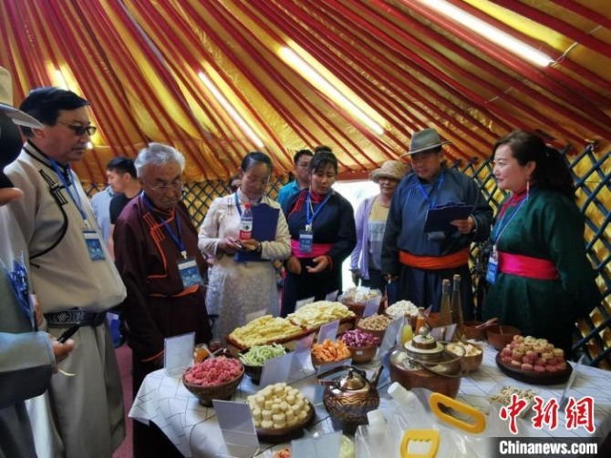 圖為貸慶(右二)正在奶食節(jié)評比活動中當評委。　管永新 攝