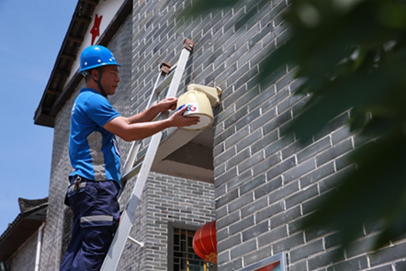 中國電信裝維工程師鐘常勇在檢修村里的攝像頭