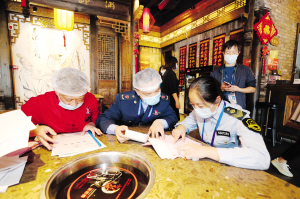 執(zhí)法人員對“小龍坎”火鍋店進行檢查。記者李海曦攝