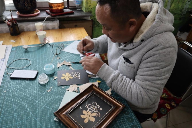 (手藝師傅正在制作樹皮畫 央視網(wǎng)記者 王靜遠(yuǎn) 攝)